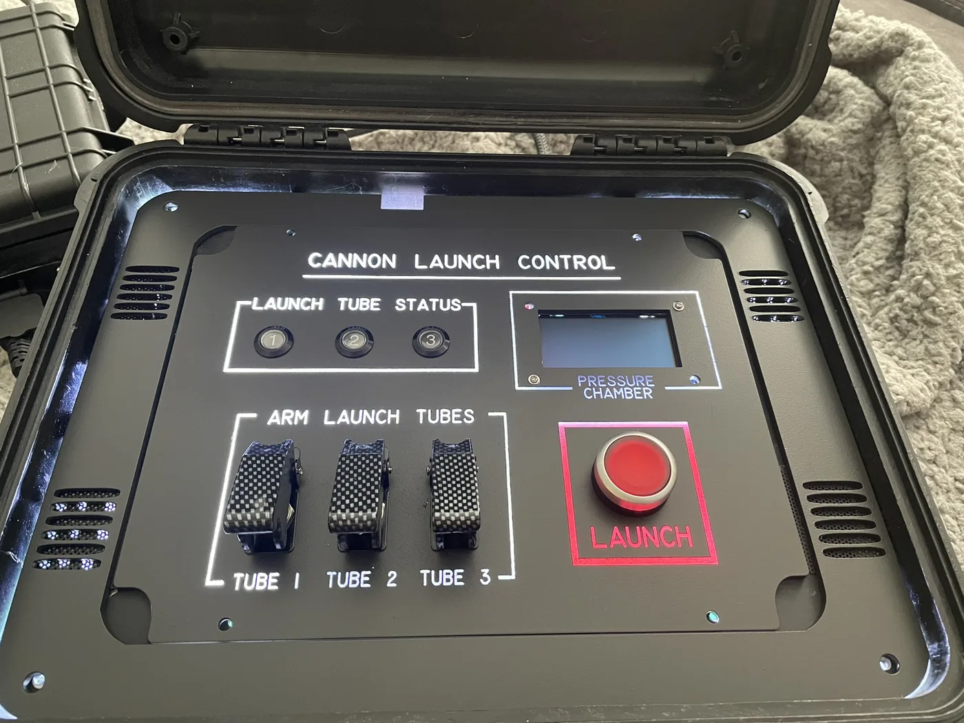Cannon launch control case: arm switches for three tubes, launch tube status lights, pressure chamber display, and a red launch button